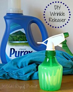 a close up of a bottle of cleaner on a table with a blue towel and green sprayer