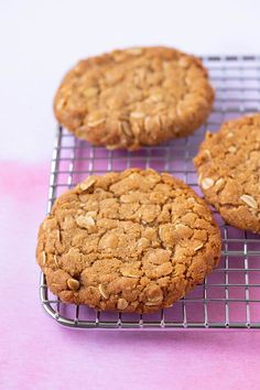 three cookies sitting on top of a cooling rack next to each other with oats