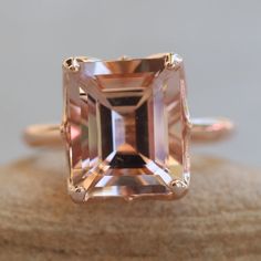 "This 5 Carat Morganite Ring features an emerald-cut genuine AAA peachy pink morganite. It is hand-set in the solid metal of your choice. Curves of metal encircle it like the leaves of a Lily Flower. The morganite is of the highest quality, averaging 12x10mm and 5.67 carats. All shapes, sizes and gemstones available upon request. VIEW THE ENTIRE \"LILY\" COLLECTION HERE: https://www.etsy.com/shop/LaurieSarahDesigns?ref=seller-platform-mcnav&section_id=24941229 ♦ SETTING DETAILS ♦ CENTER STON Morganite Wedding Band, Ring Emerald Cut, Art Deco Wedding Band, Ring Emerald, Pink Morganite, Morganite Ring, Custom Jewelry Design, Peachy Pink, Lily Flower