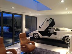 a living room filled with furniture and a sports car painted on the wall