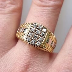 a person's hand with a gold ring on top of it and two diamonds in the middle