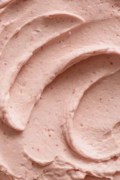 a close up view of a pink frosted cake