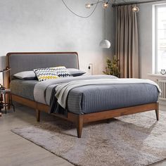 a bed sitting on top of a wooden frame in a bedroom next to a window