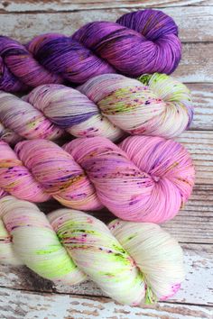 several skeins of yarn sitting on top of a wooden table