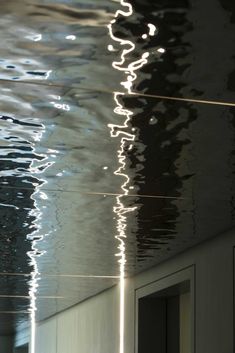 the water is reflecting light on the ceiling