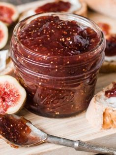 figs and bread on a cutting board with jam in a jar