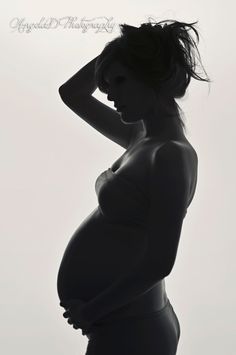 a pregnant woman is posing for a black and white photo