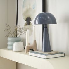 two vases and a lamp on a shelf