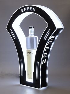 an illuminated display with a bottle in the shape of a letter and it's name is effenn