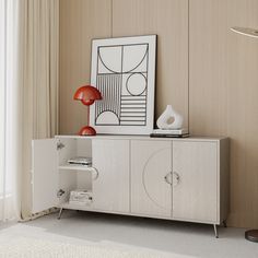 a white cabinet sitting in front of a window next to a lamp and pictures on the wall