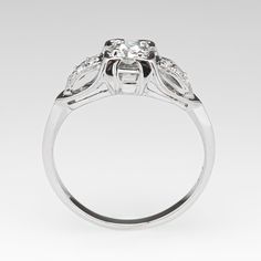 a white gold ring with three stones on the center and two diamonds in the middle