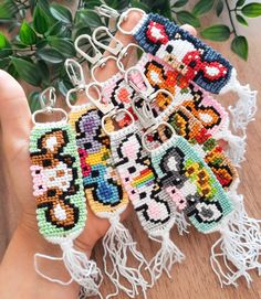 a person is holding several keychains made out of bead and yarns