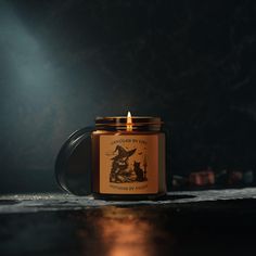 a candle that is sitting on top of a table in front of a dark background