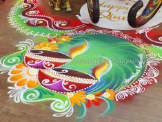 a colorful rangdi design on the ground for diwaling with horse figurines in the background