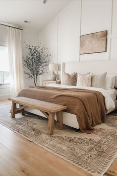 a bedroom with a bed, bench and window in the corner that overlooks an outdoor deck