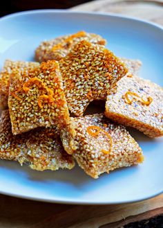 sesame seed crackers on a white plate with orange zest sprinkles