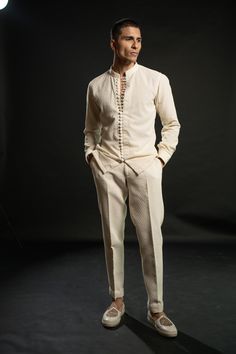 The ivory bandh gala exudes timeless elegance, crafted on silk. Its classic silhouette is adorned with intricate tonal thread embroidery, adding a touch of sophistication and refinement. Paired with a shirt boasting exquisite detailing on its buttons, the ensemble achieves a harmonious balance between tradition and modernity. Completing the ensemble are tailored pants, ensuring a seamless blend of comfort and style. This ensemble embodies understated opulence, perfect for special occasions or fo Formal Mens Fashion Wedding, Indian Wedding Outfits For Men, Embroidery Shirt Men, Mens Pants Fashion Casual, Kurta And Pants, Latest African Wear For Men, Indian Wedding Clothes For Men, Wedding Outfit For Boys, Men's Outfits By Pattern