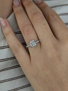 a woman's hand with a diamond ring on it