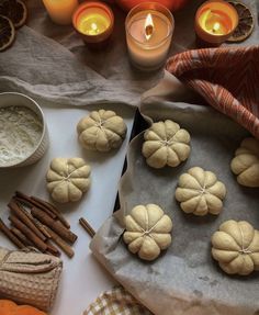 pumpkins and cinnamon sticks are on the table next to some candles, baking utensils and other items