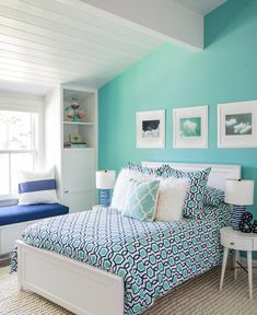 a bed room with a neatly made bed and pictures on the wall