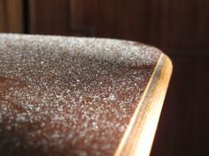 a close up view of the top of a wooden table with white powder on it