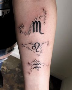 a tattoo on the arm of a woman with zodiac signs and stars around her body