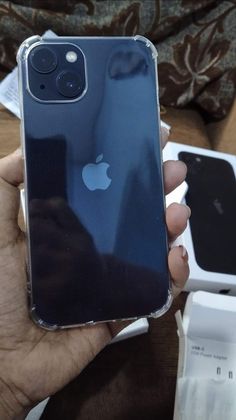 someone is holding up an iphone in their left hand, with the back cover partially open