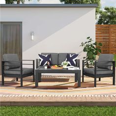 two chairs and a coffee table on a patio with a potted plant next to it