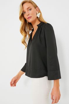 Effortlessly elevated, the Black Phillipa Blouse is a feminine silhouette that can be styled for countless occasions. This top drapes off the body in the most flattering way and features a stand collar with a gathered neckline, bracelet length sleeves, and a lightweight fabric that feels soft to the touch. Opt for light denim and sandals for a glamorous brunch look and swap for trousers and flats for a day in the office. Stand collar V-neckline Gathering on neckline and back Wide sleeves Bracele Chic Workwear Tops With Band Neckline, Chic Tops With Band Neckline For Workwear, Chic Band Neckline Tops For Work, Chic Solid Color Split Neck Blouse, Chic Solid Split Neck Blouse, Elegant Blouse With Band Neckline For Work, Elegant Top With Split Neck In Solid Color, Elegant Band Neckline Tops For Workwear, Stretch Blouson Sleeve Workwear Blouse