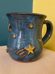 a blue ceramic mug with stars on it