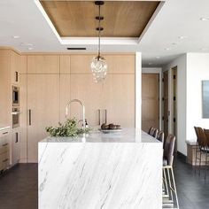 a large kitchen with marble counter tops and an island in front of the stove top