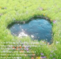 a heart shaped hole in the grass with a poem written on it that reads, fear of taking up space is a learned behavior