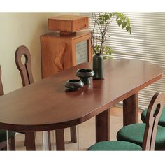 a wooden table with two vases on top of it and chairs around the table