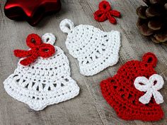 three crocheted christmas ornaments on a wooden table