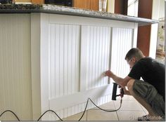 a man working on a kitchen cabinet door