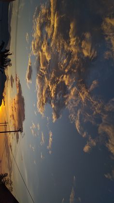 the sun is setting behind some clouds in the sky