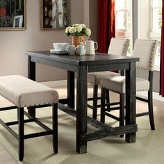 a dining room table with two chairs and a bench in front of the table is decorated with flowers