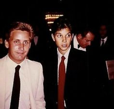 two men standing next to each other in suits and ties at a formal event together