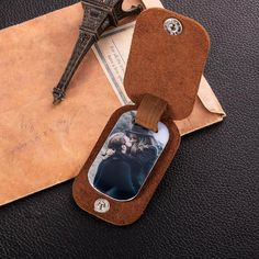 an open case with a photo inside on top of a piece of paper next to the eiffel tower