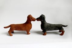 two toy dachshund dogs standing next to each other on a white background