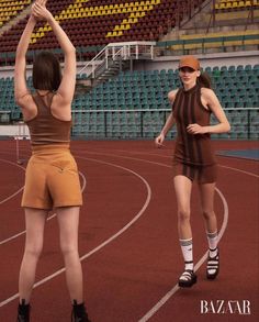 two women are standing on a track with their hands in the air