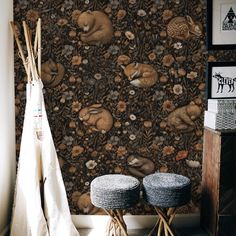 two stools in front of a wallpaper with animals on it and other decorations