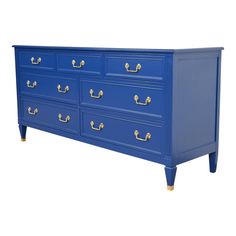 a blue dresser with gold handles on it's sides and two drawers in the middle