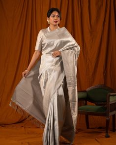 Dazzling in gilded glory, the textured Tissue Kanjivaram unveils the Ettu kol or 8 Kol in rich silver hue. The body is elegantly woven with zari and silk, accentuated with a seepu rekku border and rich pallu. These collection are treasures that are wrapped in heritage and tied with modernity.  Saree code: CL8K2139 #cliosilks #indianhandloom #weavesoftamilnadu #silksarees #iwearhandloom #kanchipattu #sareestyle #sareelove #weddingsaree #kanchipuram #kanchi #sareesusa #sareesonline #sareesovers... Saree Styles, Sarees Online, Saree Wedding, Silver