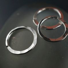 18 gauge Septum Ring / Nose Ring / Cartilage Ring - made from sterling silver - all ends are rounded / de-burred / polished - 10mm across or choose an alternate size - nickel free - measurement are INNER diameter - you open these to the side so as to retain the circle shape - this ring has a flattened lower edge that has been hammered - these are sold as singles My catchless endless rings are handmade by me with hard temper wire to ensure they retain their shape. Polished and rounded earring end Everyday Hypoallergenic Silver Septum Ring, Silver Round Cartilage Earrings Gift, Silver Hypoallergenic Nose Rings For Everyday, Adjustable White Gold Cartilage Earrings Gift, Small Hoop White Gold Rings For Gift, White Gold Small Hoop Rings As Gift, Small Hoop Stackable Piercings For Gift, Stackable Round Cartilage Earrings For Gifts, Stackable Round Cartilage Earrings As Gift