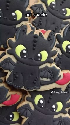 cookies decorated with black and yellow icing are arranged in rows