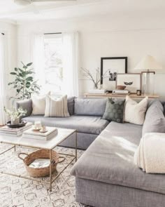 a living room filled with lots of furniture and pillows on top of a rug next to a window