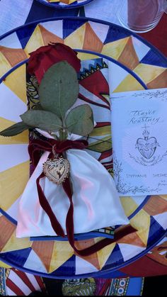 a table setting with napkins, flowers and an open note on the plate next to it