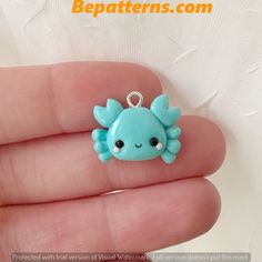 a small blue crab charm sitting on top of a person's hand with the caption bead patterns com