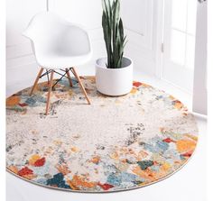 a white chair sitting on top of a rug next to a potted plant in a room